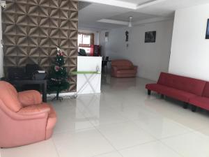 a living room with two red chairs and a christmas tree at Island Hostel in Bayan Lepas