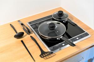 a stove top with two pots and pans on it at MUSUBI HOTEL MACHIYA Naraya-machi 1 in Fukuoka