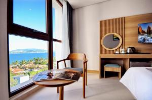 a bedroom with a bed and a table and a window at Sun Kiss Hotel in Nha Trang