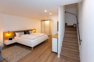 ein Schlafzimmer mit einem weißen Bett und einer Treppe in der Unterkunft Alpen-Ferienwohnung Ginova in Garmisch-Partenkirchen