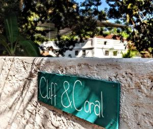 a sign on a wall that reads cafe end at Cliff & Coral in Varkala