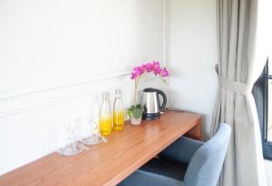 a wooden table with glasses and a vase with flowers on it at Casa Narrow Villa in Nembrala