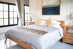 a bedroom with a large bed with a painting on the wall at Casa Narrow Villa in Nembrala