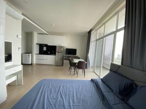 a bedroom with a bed and a kitchen with a table at The Hill Residence in Sihanoukville
