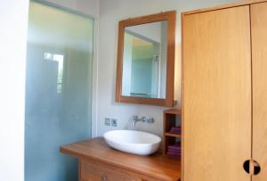 a bathroom with a white sink and a mirror at Casa Narrow Villa in Nembrala