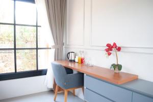 a kitchen with a wooden desk in front of a window at Casa Narrow Villa in Nembrala