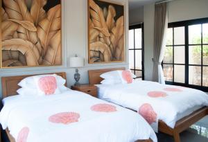 two beds in a room with a painting on the wall at Casa Narrow Villa in Nembrala