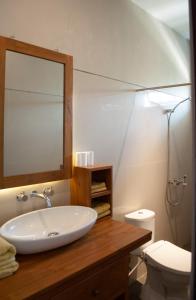 a bathroom with a sink and a toilet and a mirror at Casa Narrow Villa in Nembrala