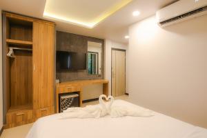 a bedroom with a bed with a swan decoration on it at The Mantra Hotel Kata Noi in Kata Beach