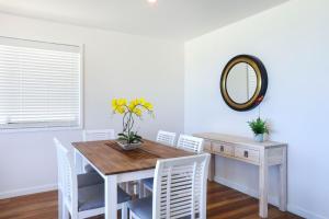 a dining room table with a vase of flowers on it at Sandbox Apartments in Gold Coast