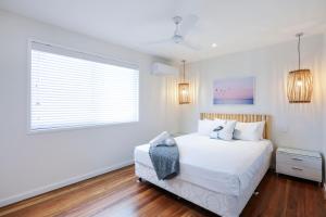 a bedroom with a white bed and white walls at Sandbox Apartments in Gold Coast