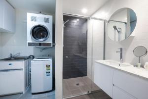 a bathroom with a shower and a washing machine at Sandbox Apartments in Gold Coast