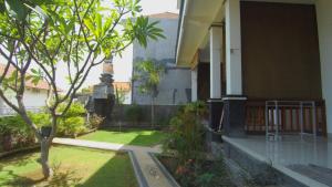 a courtyard of a house with a tree and grass at Rivera Beach in Amed