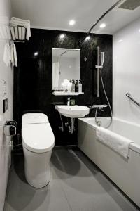 ein schwarz-weißes Badezimmer mit Toilette und Waschbecken in der Unterkunft Hotel Dans Le Coeur Osaka Umeda in Osaka + 46 Fotos