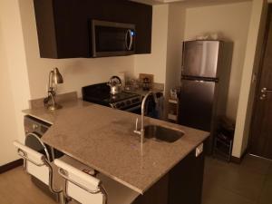 a kitchen with a sink and a refrigerator at El mejor apartamento en excelente ubicación. in San José
