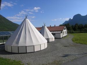 two large white tents parked next to a building at Welcome Inn Hotel Lyngskroa in Oteren