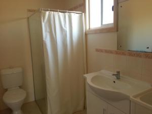 a bathroom with a shower curtain and a sink at Sonbern Lodge Motel in Wallaroo