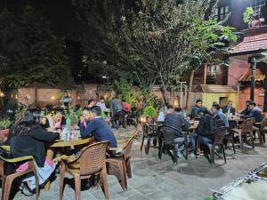 people sitting at tables at a restaurant at night at Nag Pukhu Guest House in Bhaktapur