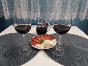 dos copas de vino tinto y un plato de carne y queso en Apartmani Krtolica, en Novi Sad 37 fotos más