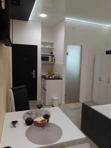 cocina con mesa y 2 copas de vino en Apartmani Krtolica, en Novi Sad