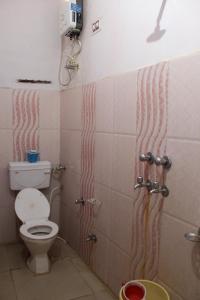 a bathroom with a toilet and a shower stall at Sunset Backpackers Hostel in Orchha