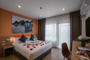 a hotel room with a bed with roses on it at 7 Days Premium Hotel Don Meaung Airport in Ban Don Muang (1)