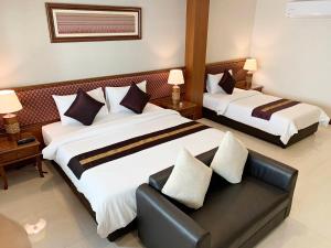 a hotel room with two beds and a couch at True Siam Rangnam Hotel in Bangkok