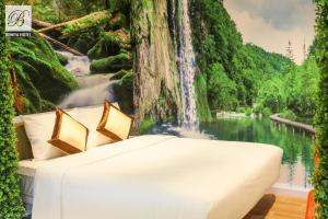 1 cama en una habitación con un mural de cascada en Bonita THT en Ho Chi Minh