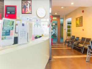 a waiting room with chairs and a clock on the wall at OYO 89408 Royal Hotel in Keningau