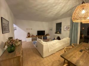 a living room with a white couch and a table at Can Nicasi in L'Escala