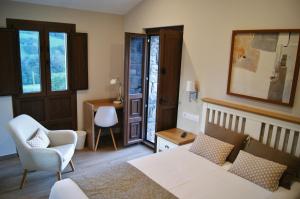 PeñerudesにあるApartamentos Rurales Peñon Blancoのベッドとソファと椅子のある寝室