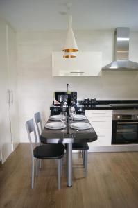 PeñerudesにあるApartamentos Rurales Peñon Blancoのキッチン(テーブル、椅子、ワイングラス付)