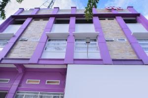 un edificio púrpura con un signo de hola gatito en él en SUPER OYO Capital O 2018 Ring Road Guest House Syariah en Banda Aceh