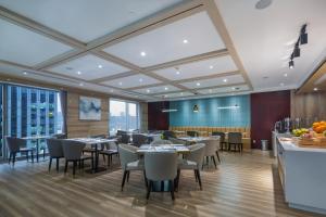 a restaurant with tables and chairs in a room at Shama Heda Serviced Apartment in Hangzhou