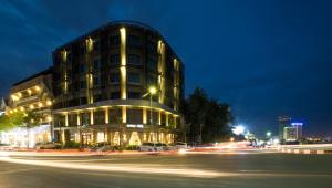 a building on a city street at night at Almond Hotel Bassac River in Phnom Penh
