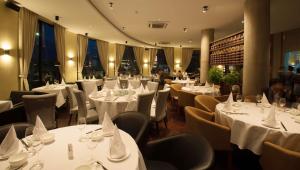 a restaurant with tables and chairs with white table cloth at Almond Hotel Bassac River in Phnom Penh