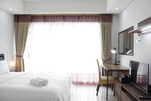 a hotel room with a bed and a window at Strategic Studio at Green Kosambi Bandung Apartment By Travelio in Bandung