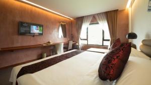 1 dormitorio con 1 cama blanca grande en una habitación en Almond Hotel Bassac River, en Phnom Penh