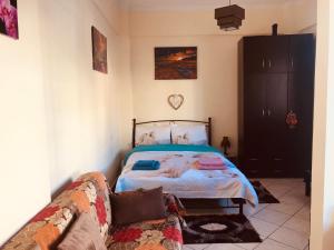 a bedroom with a bed and a couch at See and City Apartment in Aigio