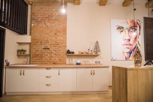 a kitchen with white cabinets and a brick wall at Casa Verde - Brasov Homes in Braşov