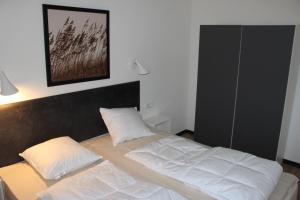 1 cama con 2 almohadas en una habitación en Dünenhaus Wohnung 6, en Lübeck