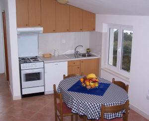 una cocina con una mesa con un bol de fruta. en Seven Seas Apartments, en Mlini