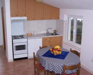 a kitchen with a table with a bowl of fruit on it at Seven Seas Apartments in Mlini +16 photos