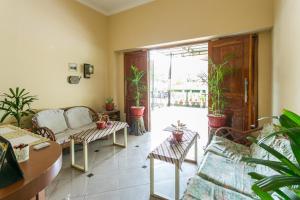 a living room with a couch and chairs and potted plants at RedDoorz Syariah @ Sakinah Guesthouse in Sragen