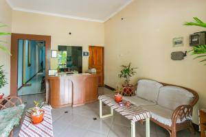 - un salon avec un canapé et une table dans l'établissement RedDoorz Syariah @ Sakinah Guesthouse, à Sragen