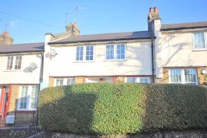 a hedge in front of a large white house at Tooting Lodge London - Cosy 2 bedroom house with garden in London
