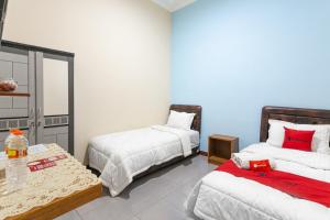 Voodi või voodid majutusasutuse RedDoorz Syariah @ Sakinah Guesthouse toas