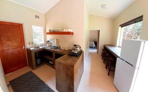 a kitchen with a desk and a refrigerator and a table at Echo Caves in Ohrigstad