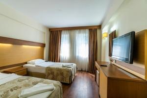 a hotel room with two beds and a flat screen tv at Afytos Bodrum City in Mugla