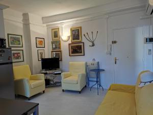 カンヌにあるKarolのリビングルーム(黄色い椅子、テレビ付)